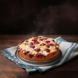 freshly baked cherry cake with almond slivers on a blue kitchen 